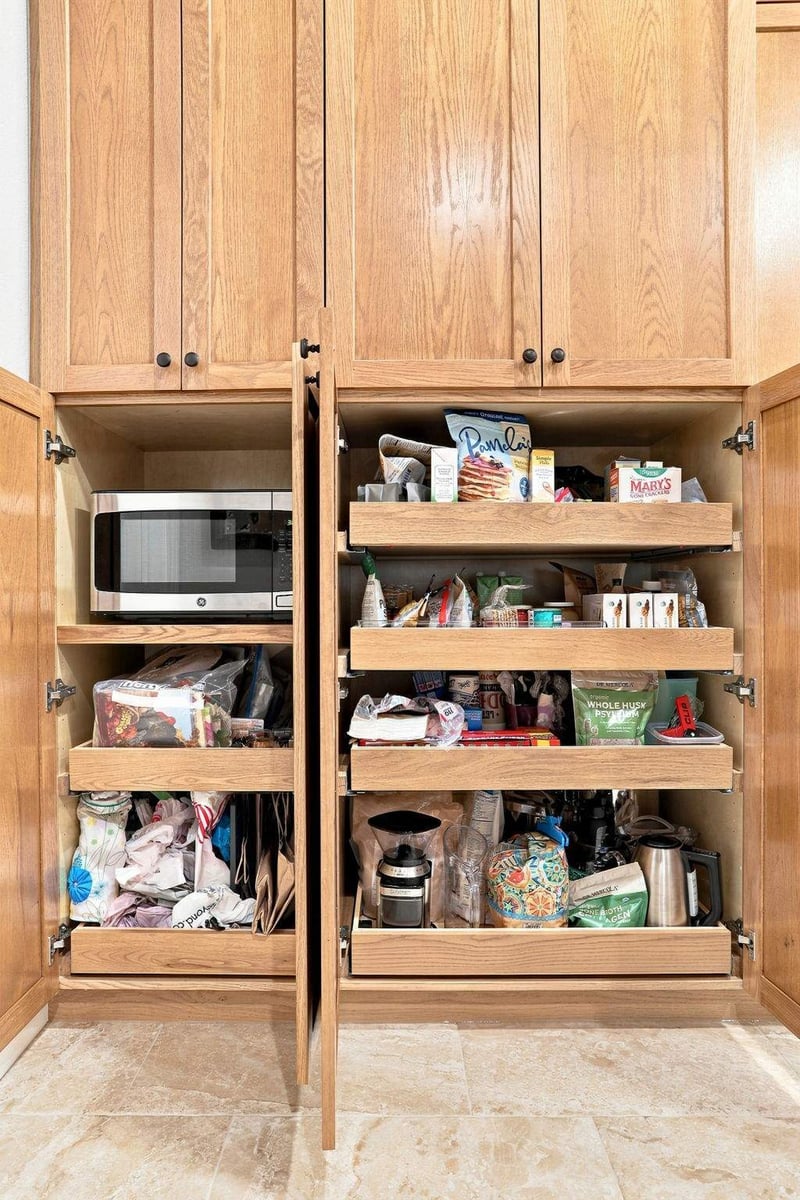 Tall kitchen pantry cabinet featuring multiple pullout shelves for organized food and appliance storage.