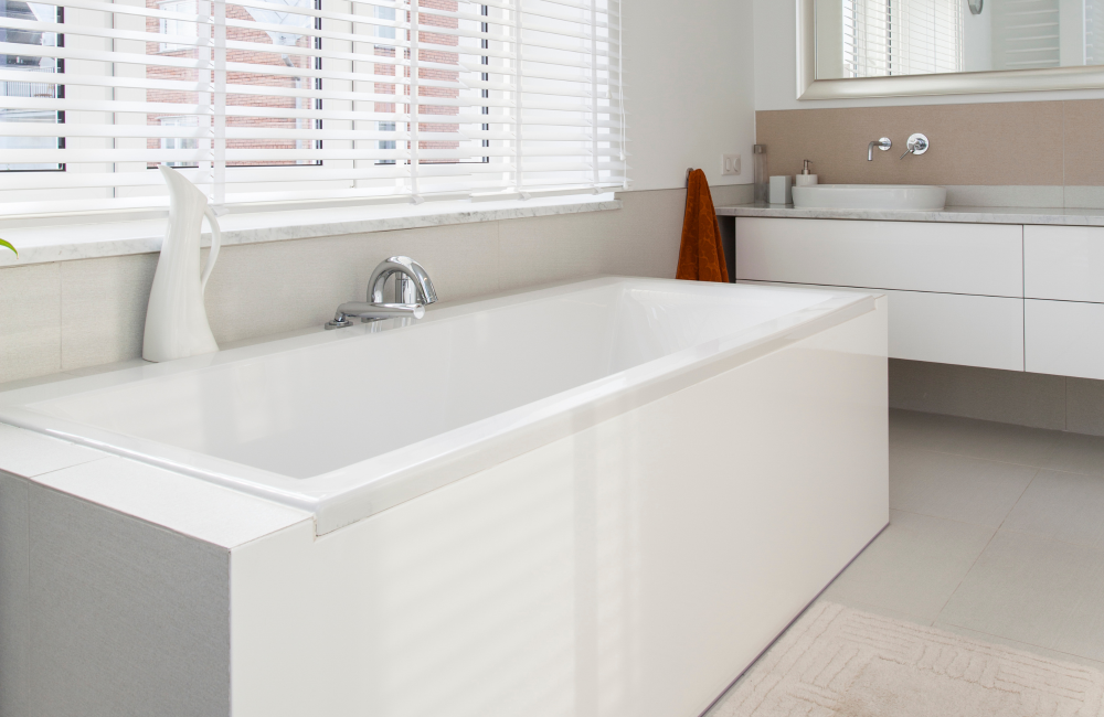 White tub in bathroom in front of window