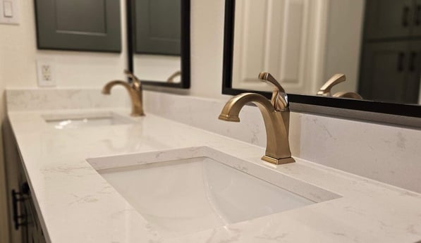 Double sink with gold faucets in San Antonio bathroom remodel