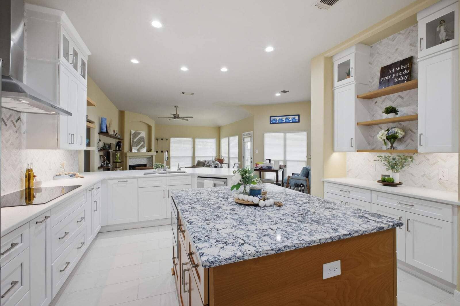 Spacious San Antonio kitchen remodel with white cabinets, wood island, open shelving, and bright lighting.