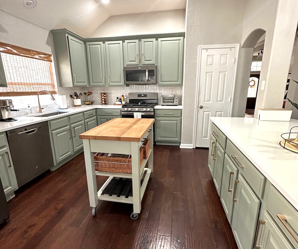 Kitchen with seafoam green cabinets and dark wood floors