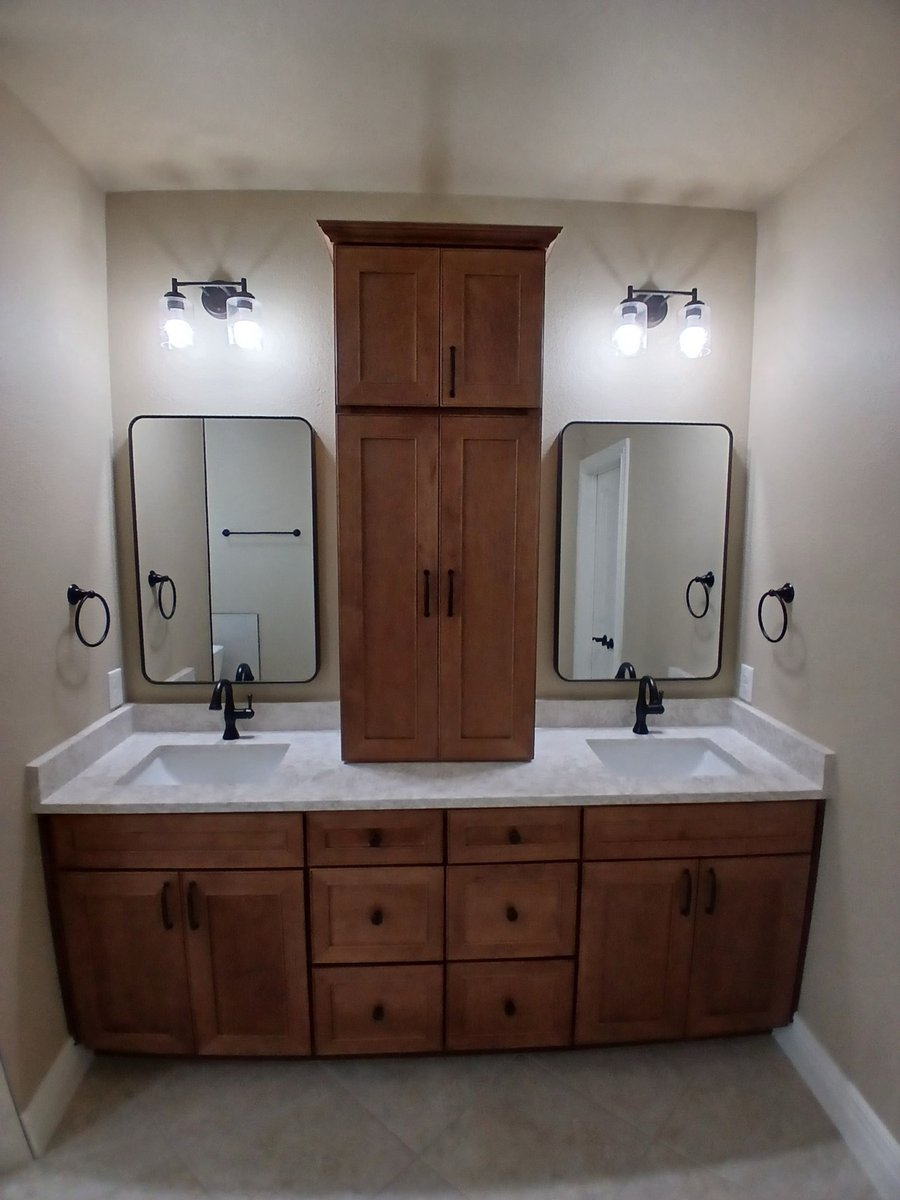 Symmetrical maple double vanity with tall center tower and twin framed mirrors