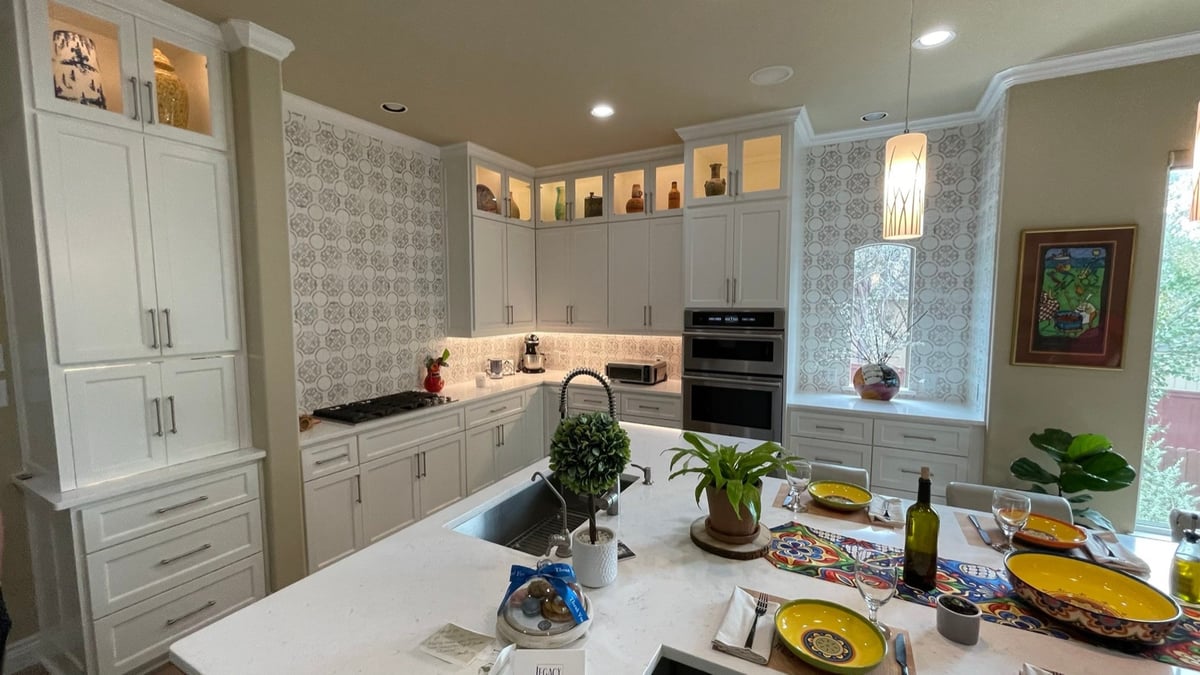 Updated kitchen corner with floor-to-ceiling patterned tile and glass-front upper cabinets