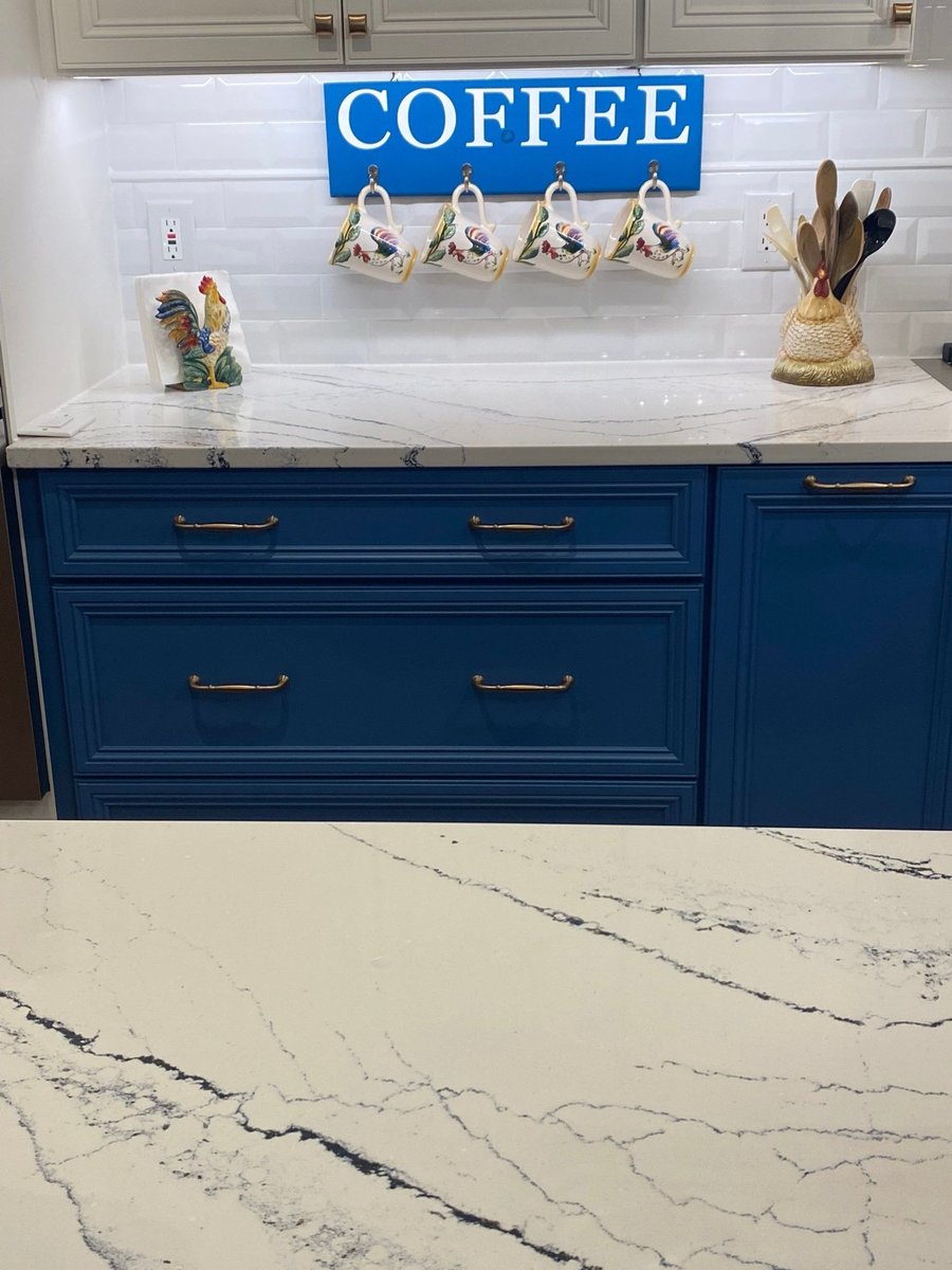 Long white quartz counter run with gas cooktop and butter dish