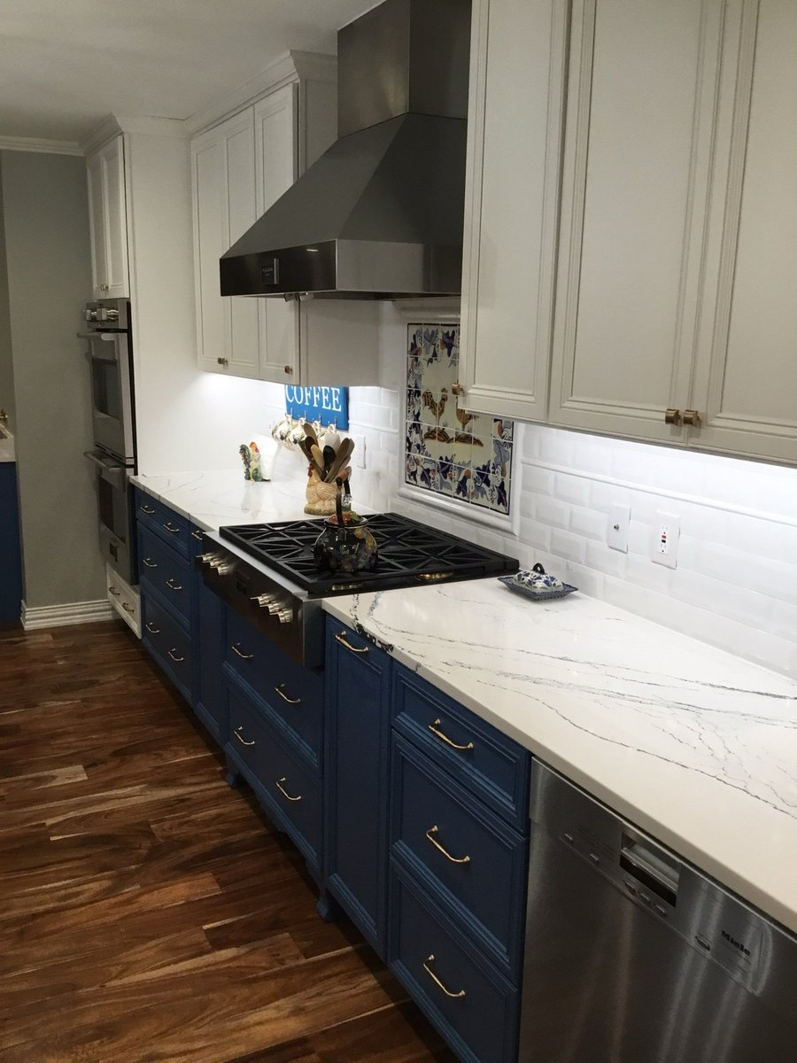Panel-front built-in refrigerator beside tall stainless wine cooler