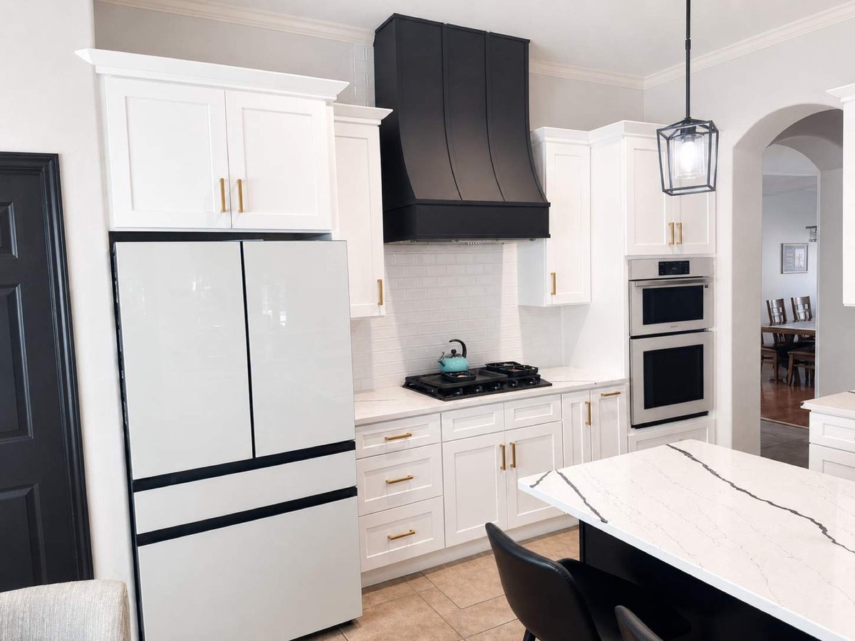 White kitchen with black range hood, gas cooktop and double wall ovens