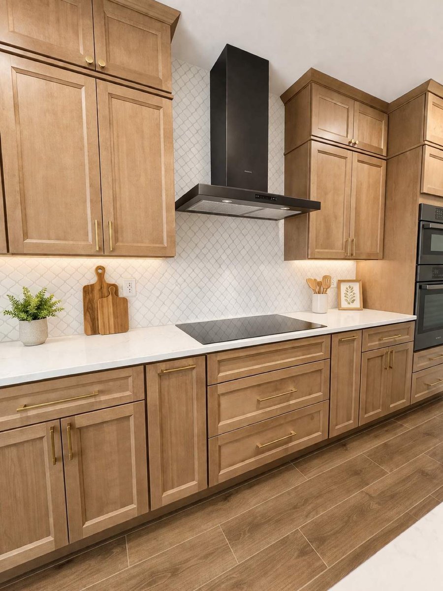 Stained shaker cabinets with gold hardware, black chimney hood and induction cooktop