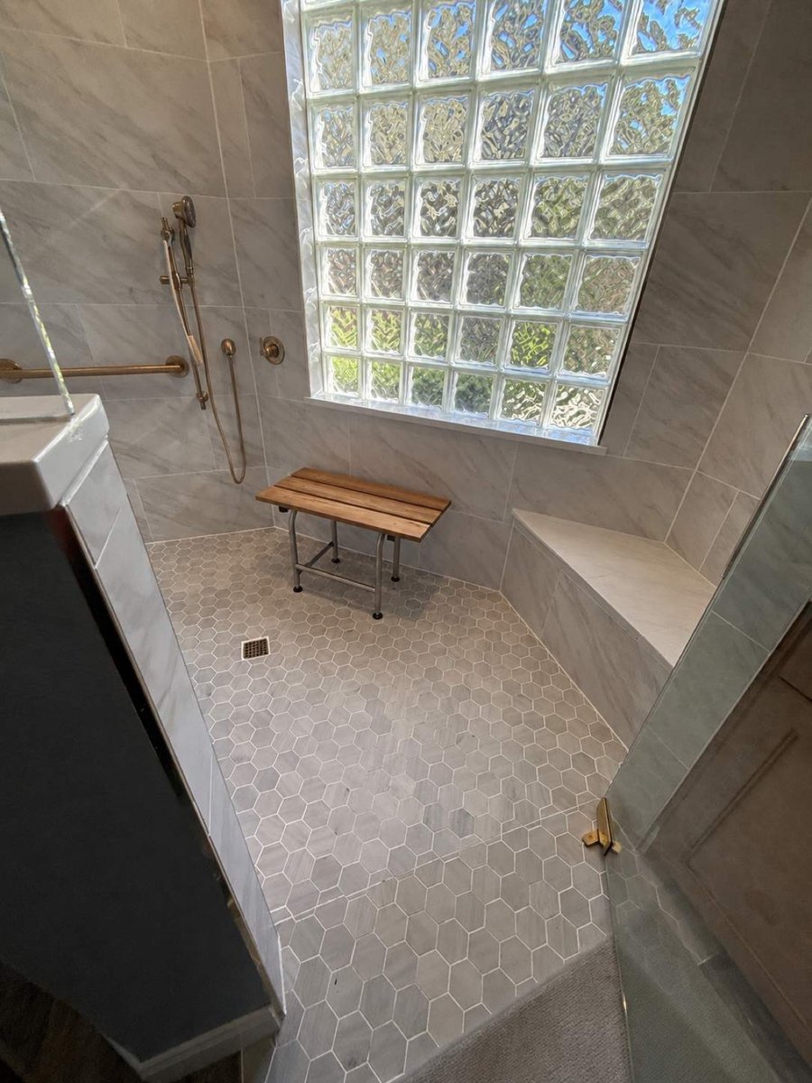 Roll-in shower with folding teak seat under glass block window