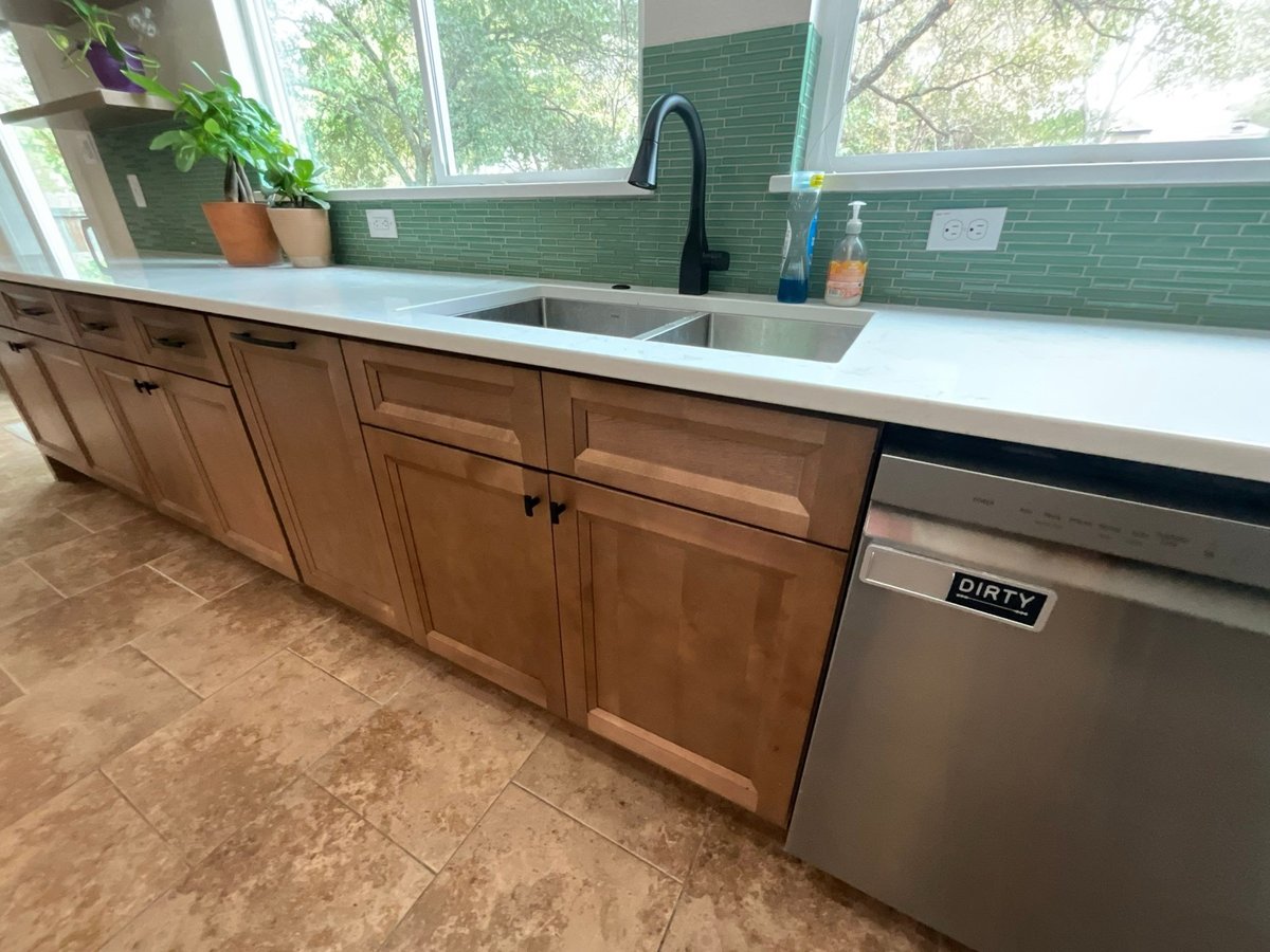 Maple cabinets with green glass backsplash, double sink and stainless dishwasher