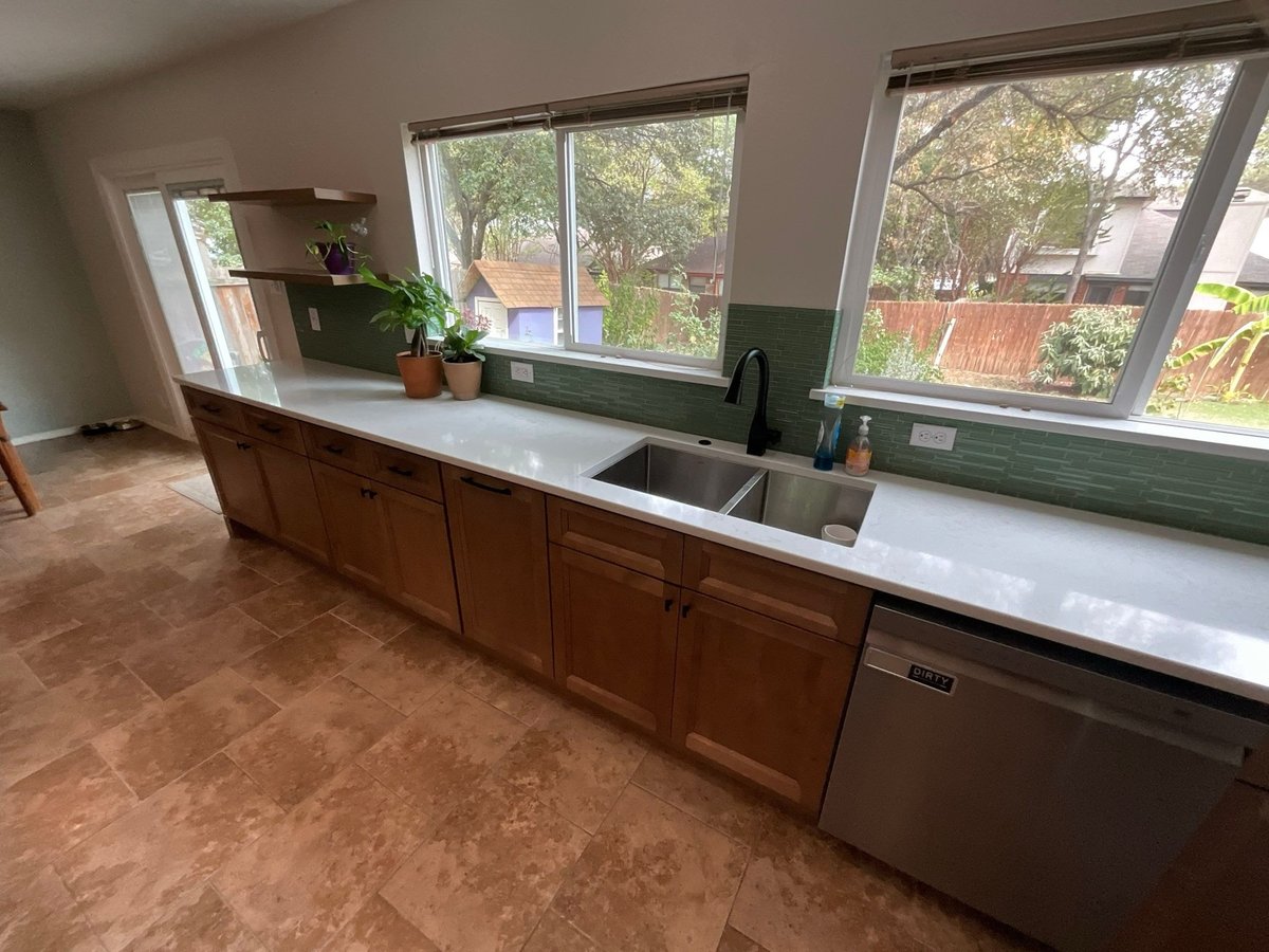 Long counter run with windows, green tile backsplash and stainless dishwasher