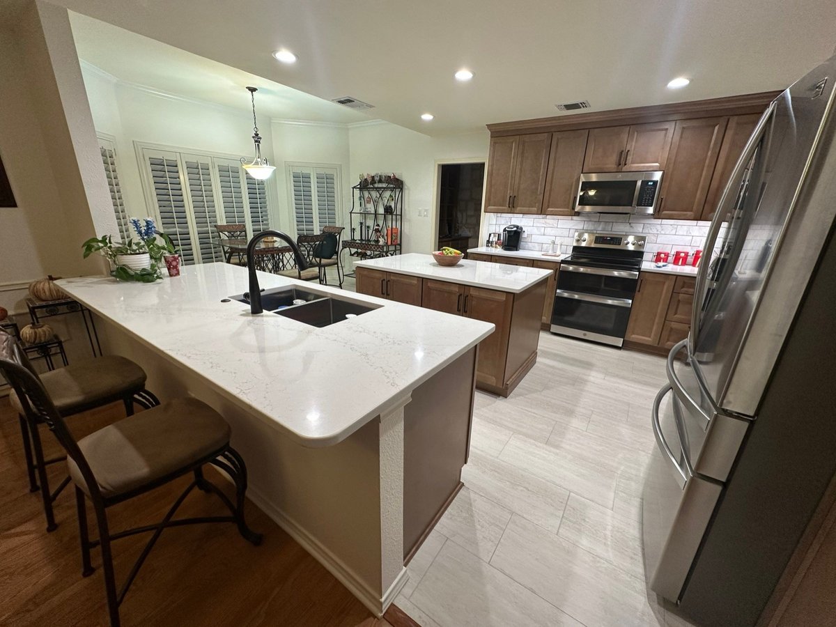 Open kitchen with wood cabinets, quartz island and stainless appliances