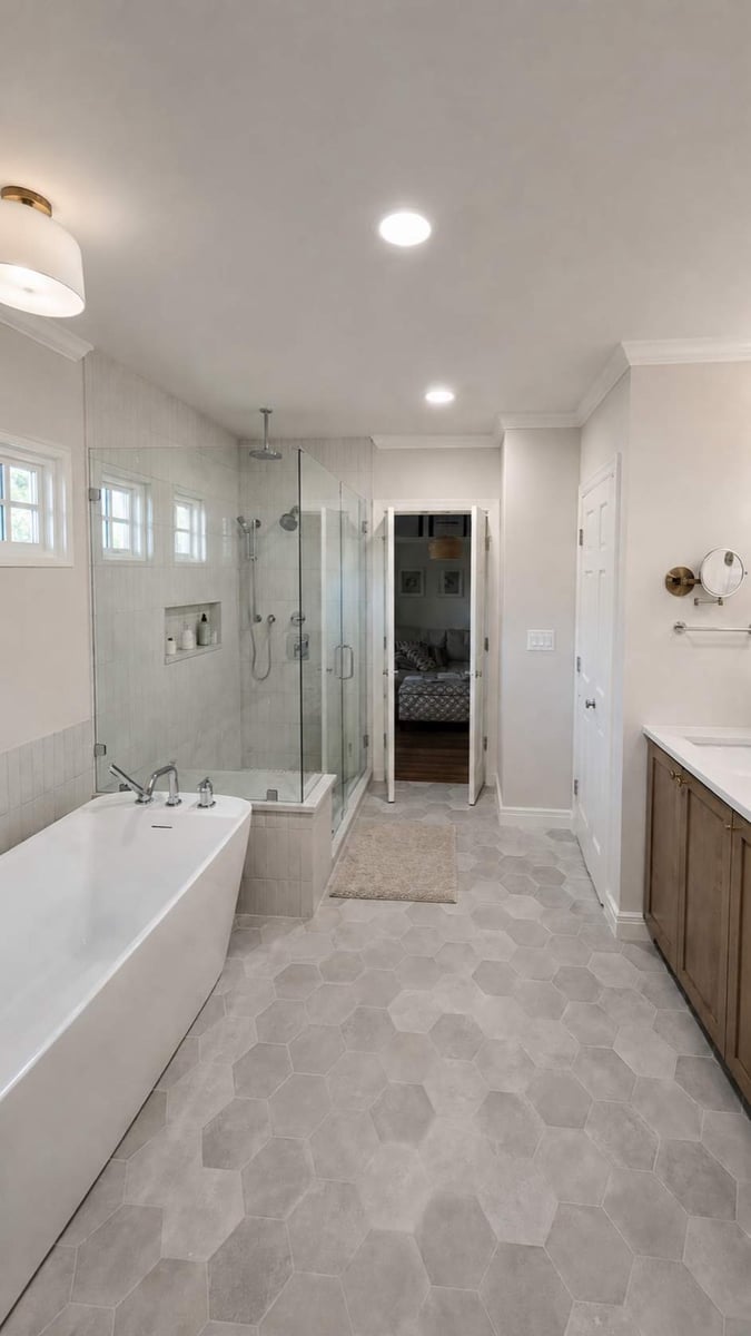 Long master bath with freestanding tub, corner glass shower, and hexagon tile floor