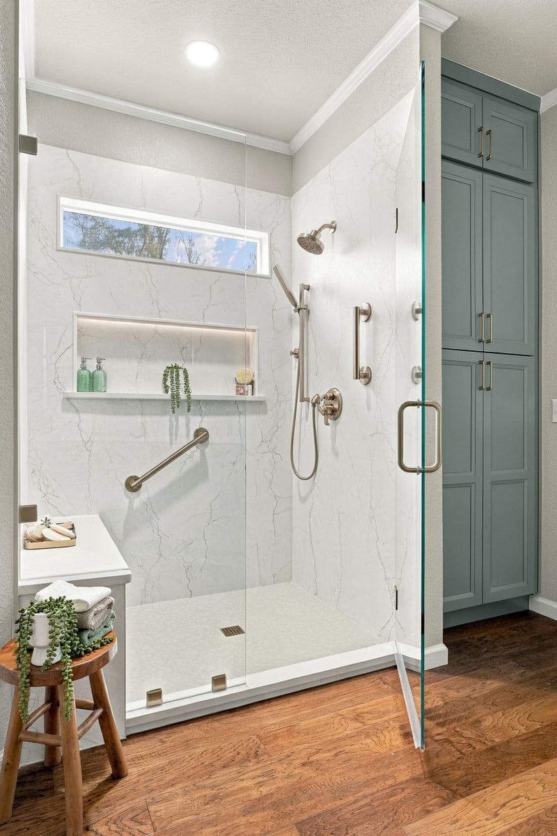 San Antonio tub-to-shower conversion featuring a spacious walk-in shower with frameless glass enclosure, marble-look wall panels, built-in bench, and brass fixtures.