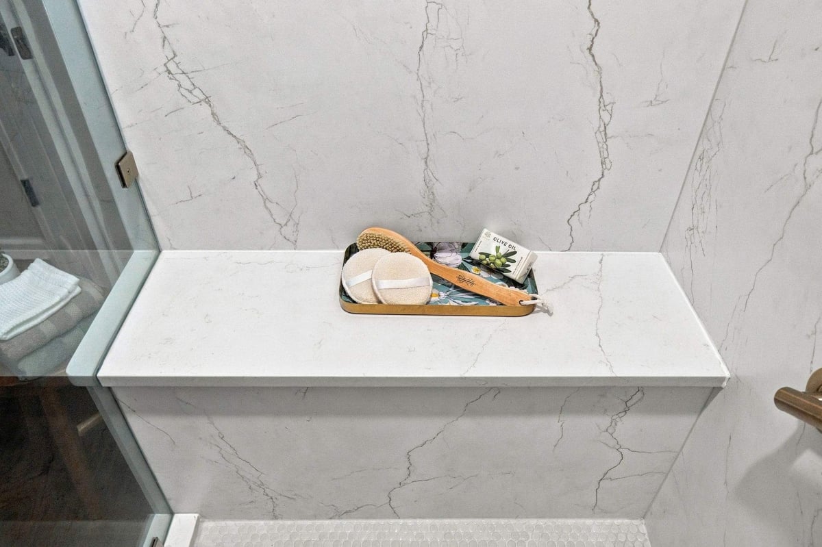 Built-in shower bench with marble-look wall panels in a San Antonio tub-to-shower conversion, providing comfortable seating in the spacious walk-in shower.