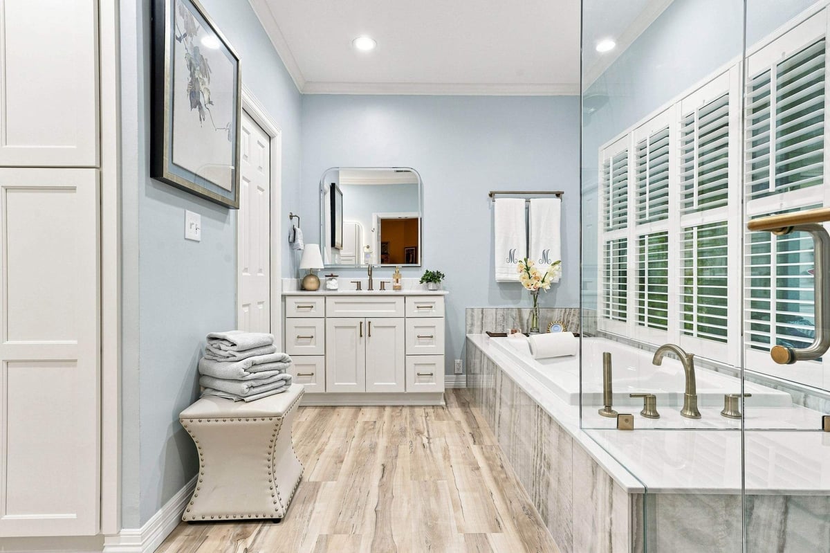 Spacious Deerfield primary bathroom with white vanity, jetted tub, and coordinated finishes.