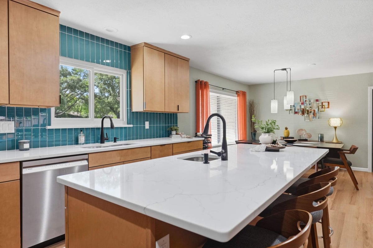 Large white kitchen island with seating and warm wood cabinetry