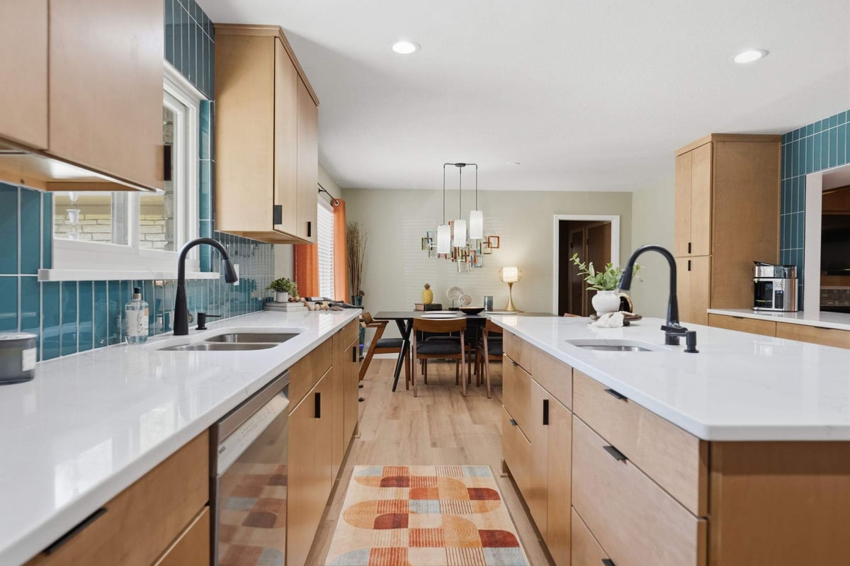 Mid-century kitchen remodel with teal backsplash, wood cabinets and white countertops