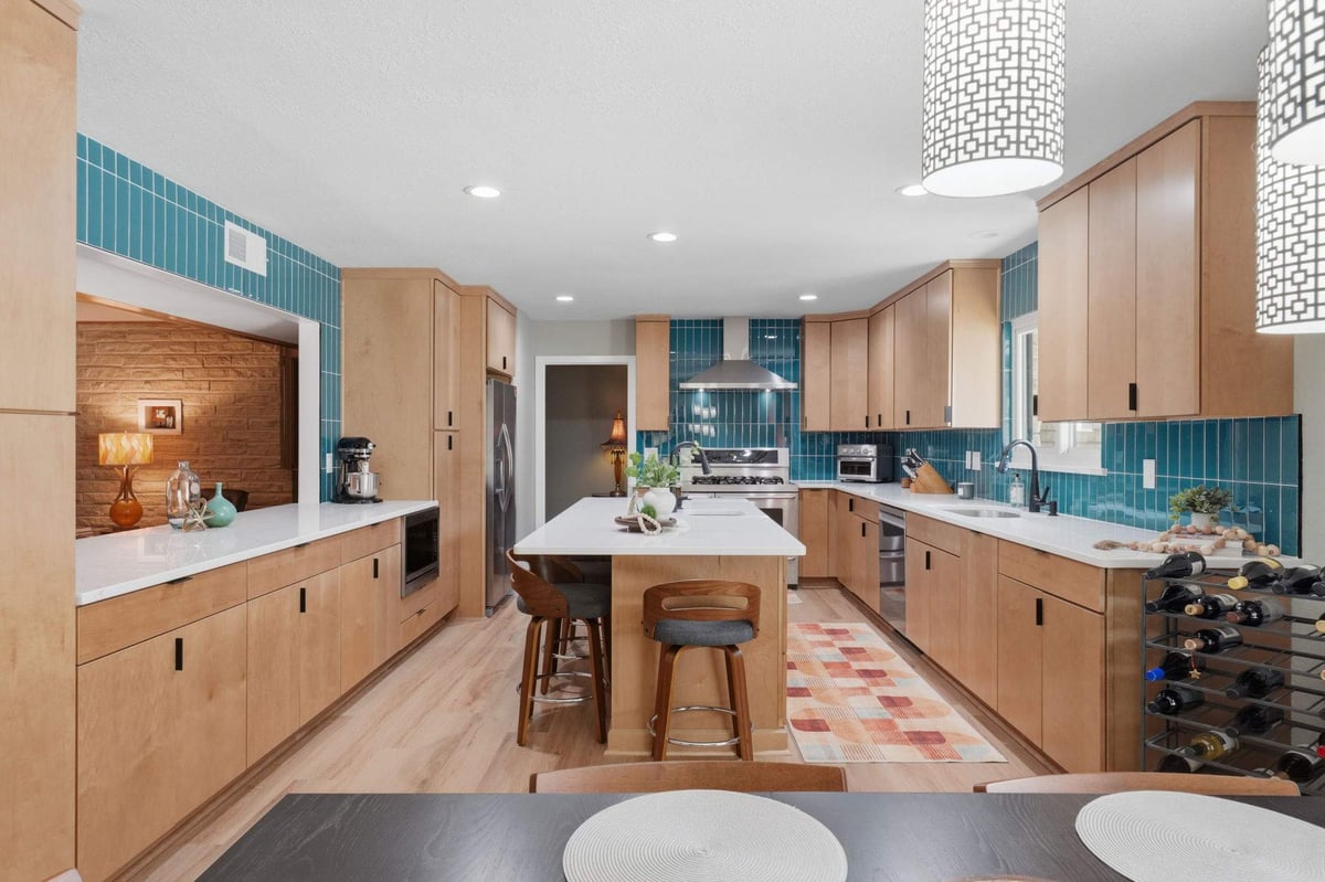 Open mid-century modern kitchen with central island and natural wood cabinetry