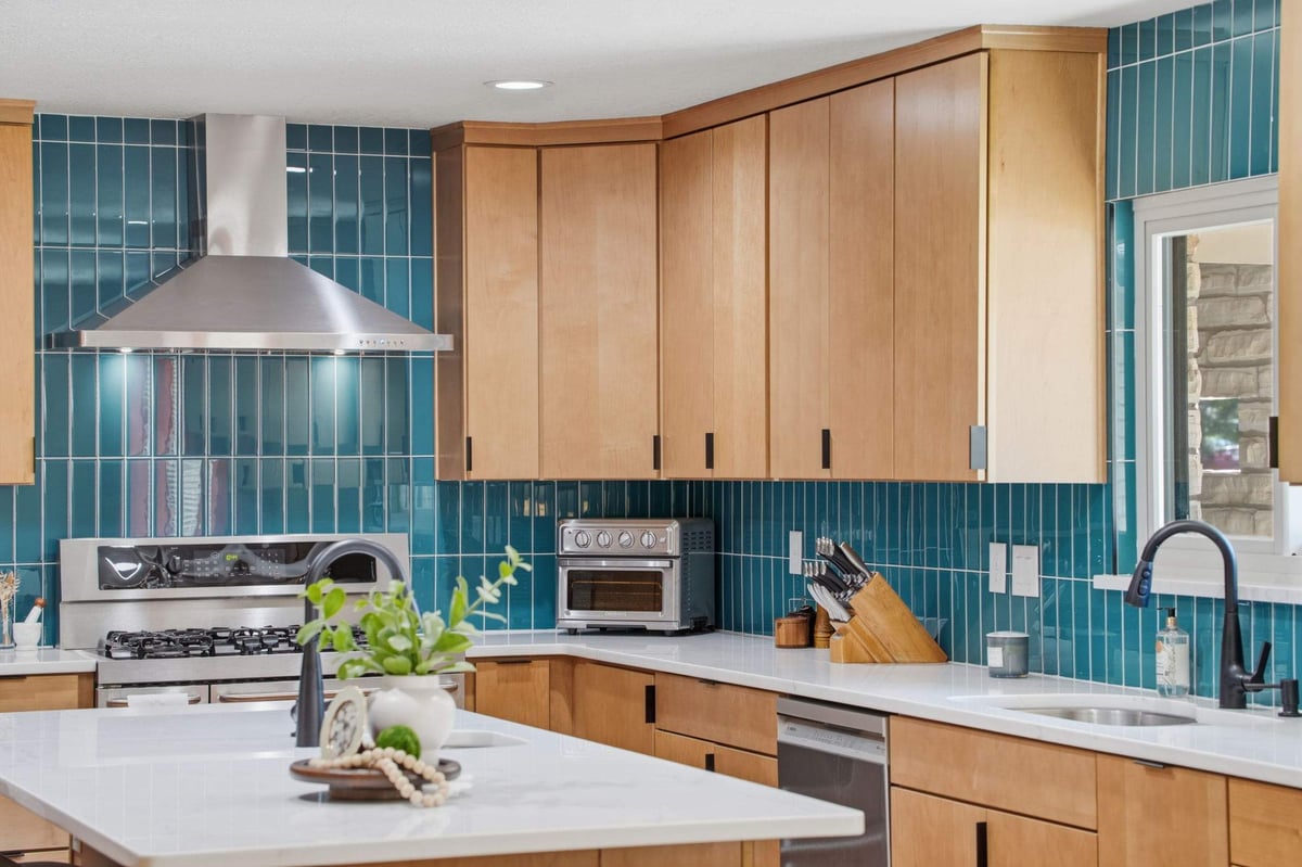 Warm wood kitchen cabinets with teal tile backsplash in Castle Hills remodel
