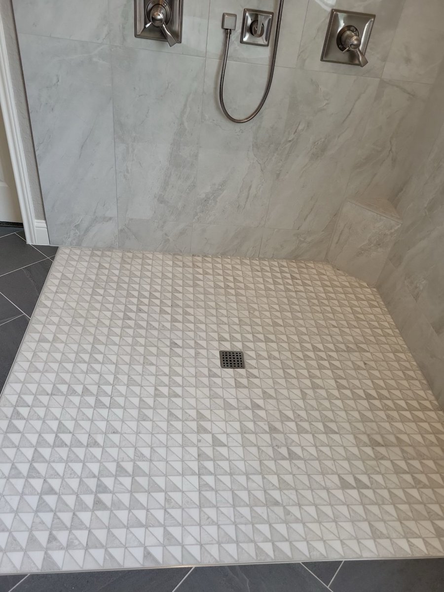Walk-in shower mosaic floor with center drain and brushed nickel fixtures