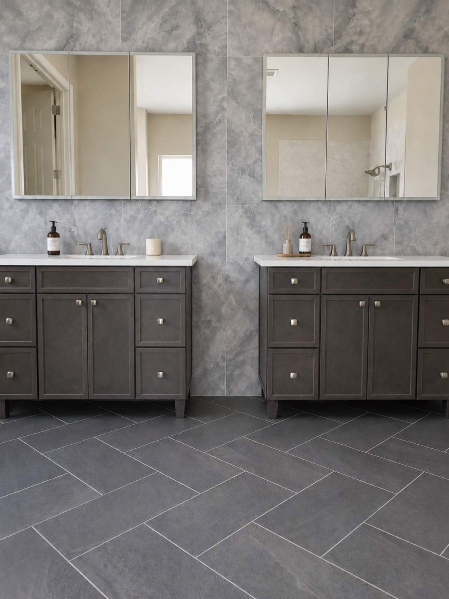 Two gray vanities with medicine cabinet mirrors over herringbone tile floor