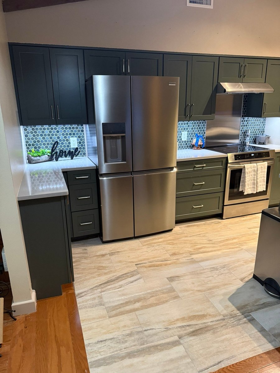 Green cabinets with blue penny-tile backsplash and stainless French-door fridge