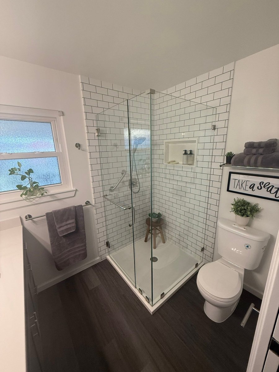 Small bath with white subway-tiled glass corner shower and white toilet