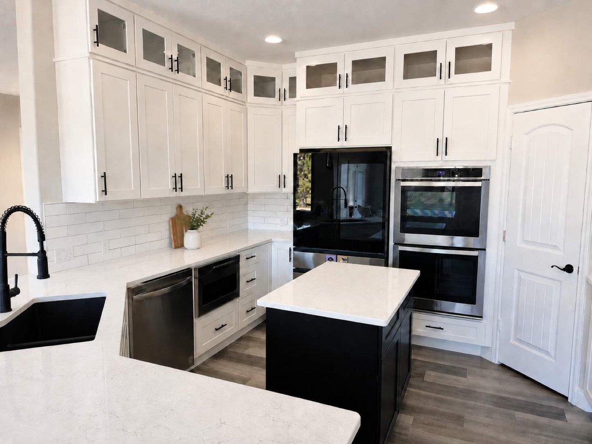 White kitchen with glass-front cabinets, black appliances and dark island