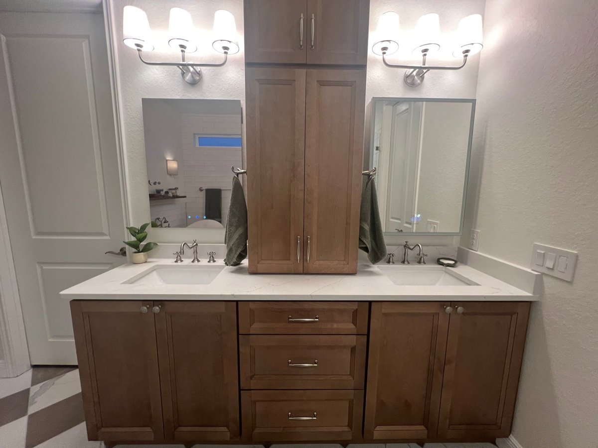 Wood double vanity with sconces, mirrors and central tower cabinet