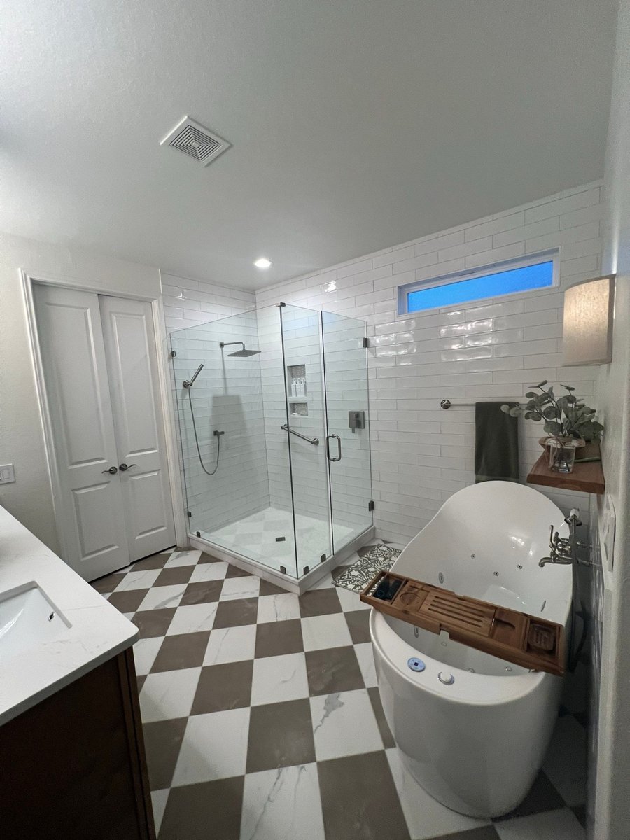 Master bath with white subway tile shower, freestanding tub and checkered floor