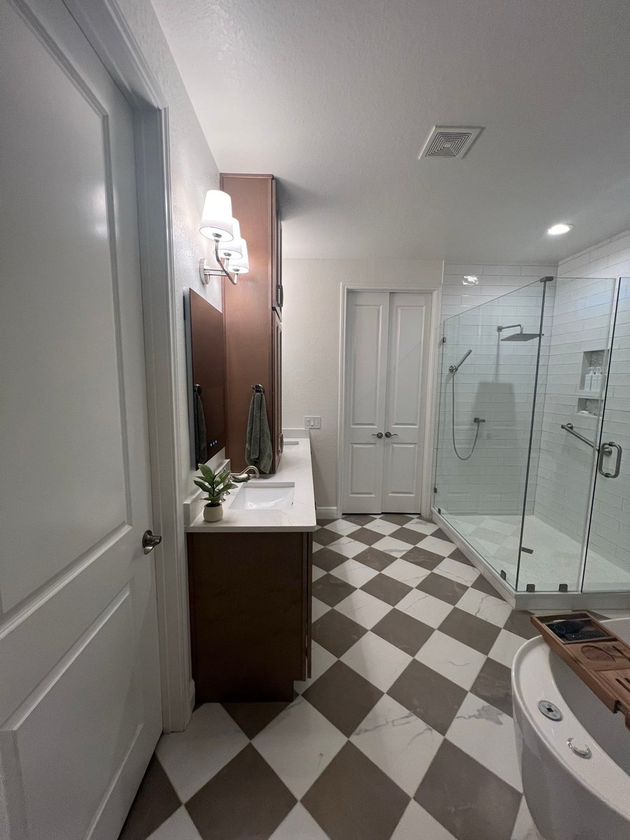 Bathroom with wood vanity, corner glass shower and brown-and-white checkered floor