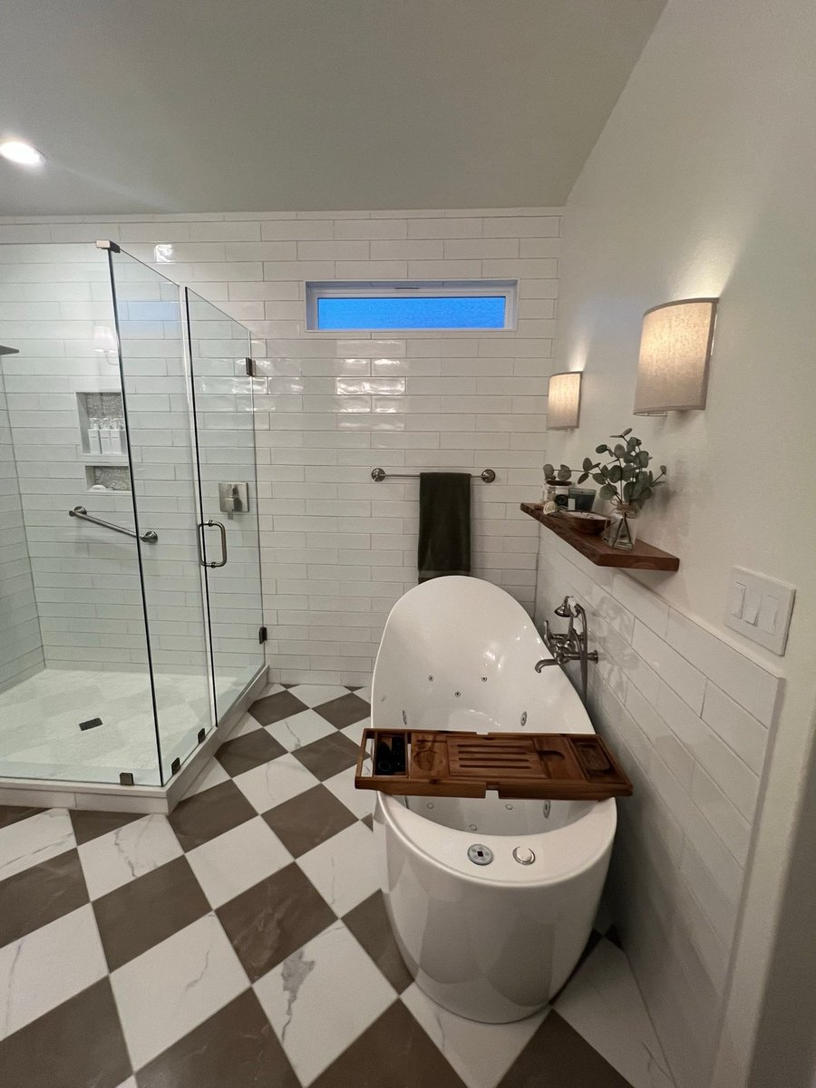 Glass walk-in shower with subway tile, niche shelf and freestanding tub