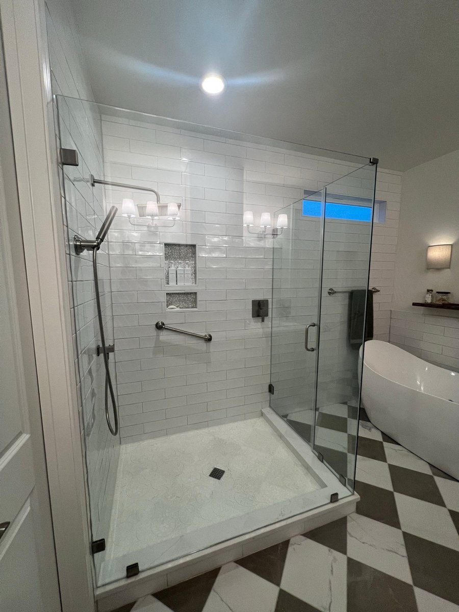 Walk-in shower with black rainfall head, white subway tile and built-in niches