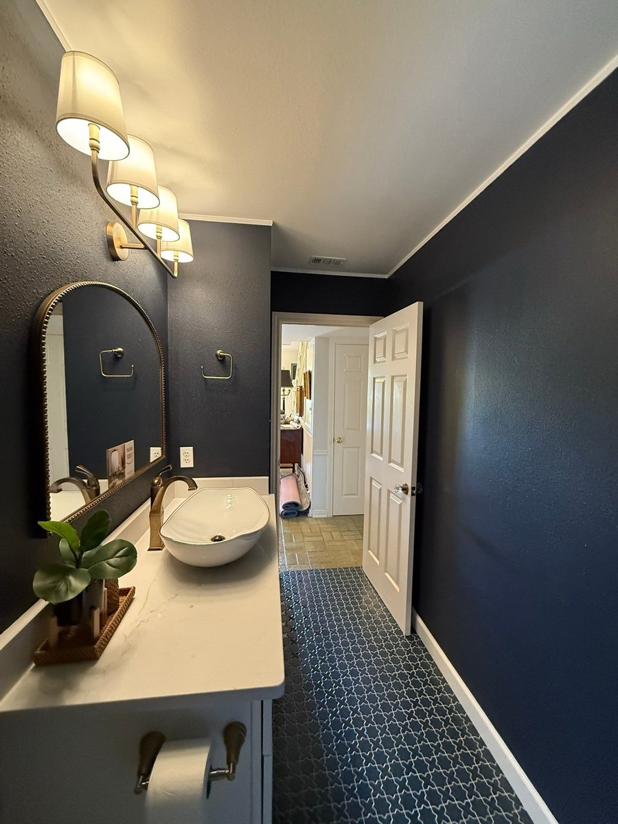 Navy bath with beaded mirror, brass faucet vessel sink and patterned tile