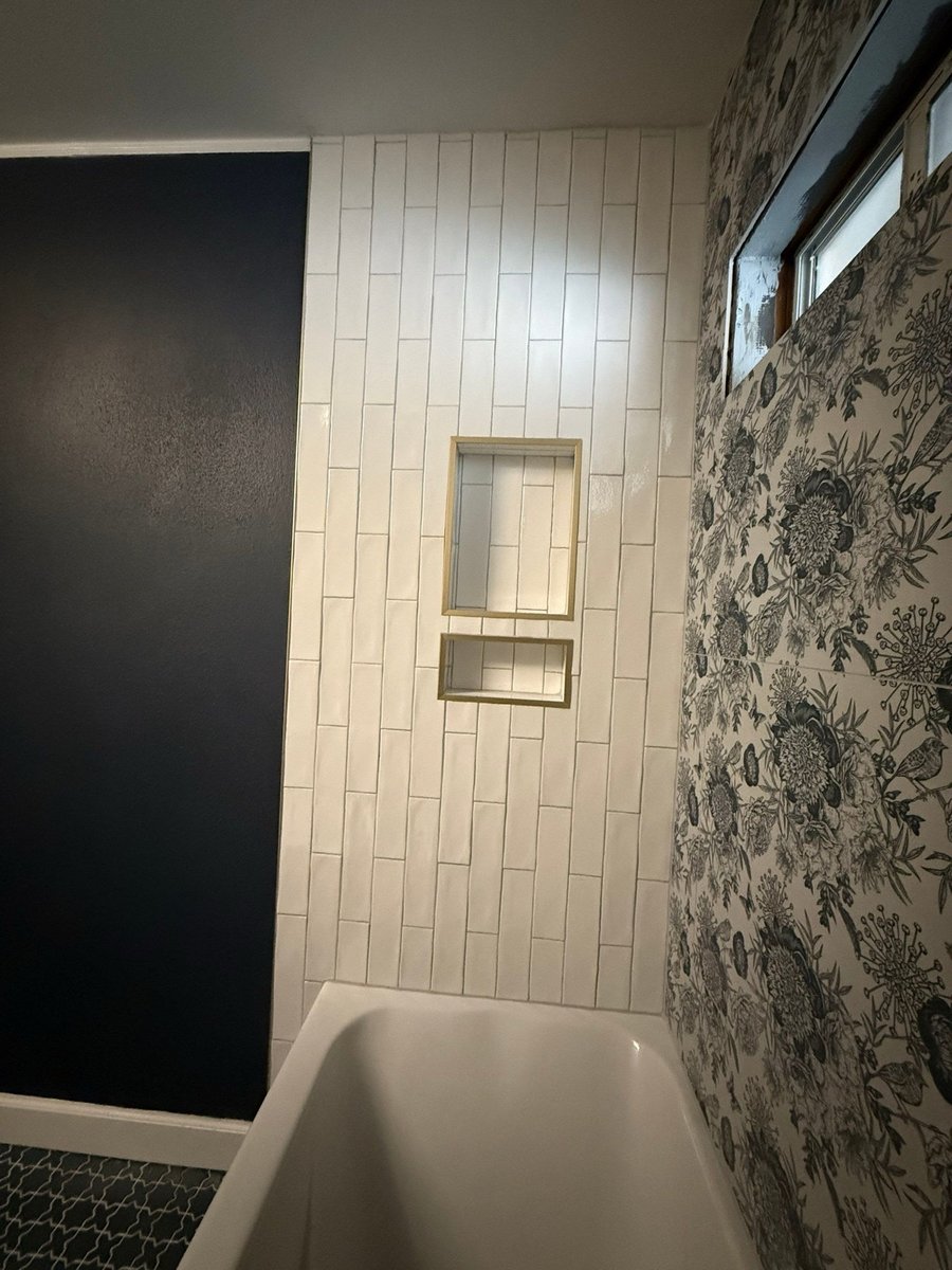 White tile tub surround with double recessed niche by floral wallpaper