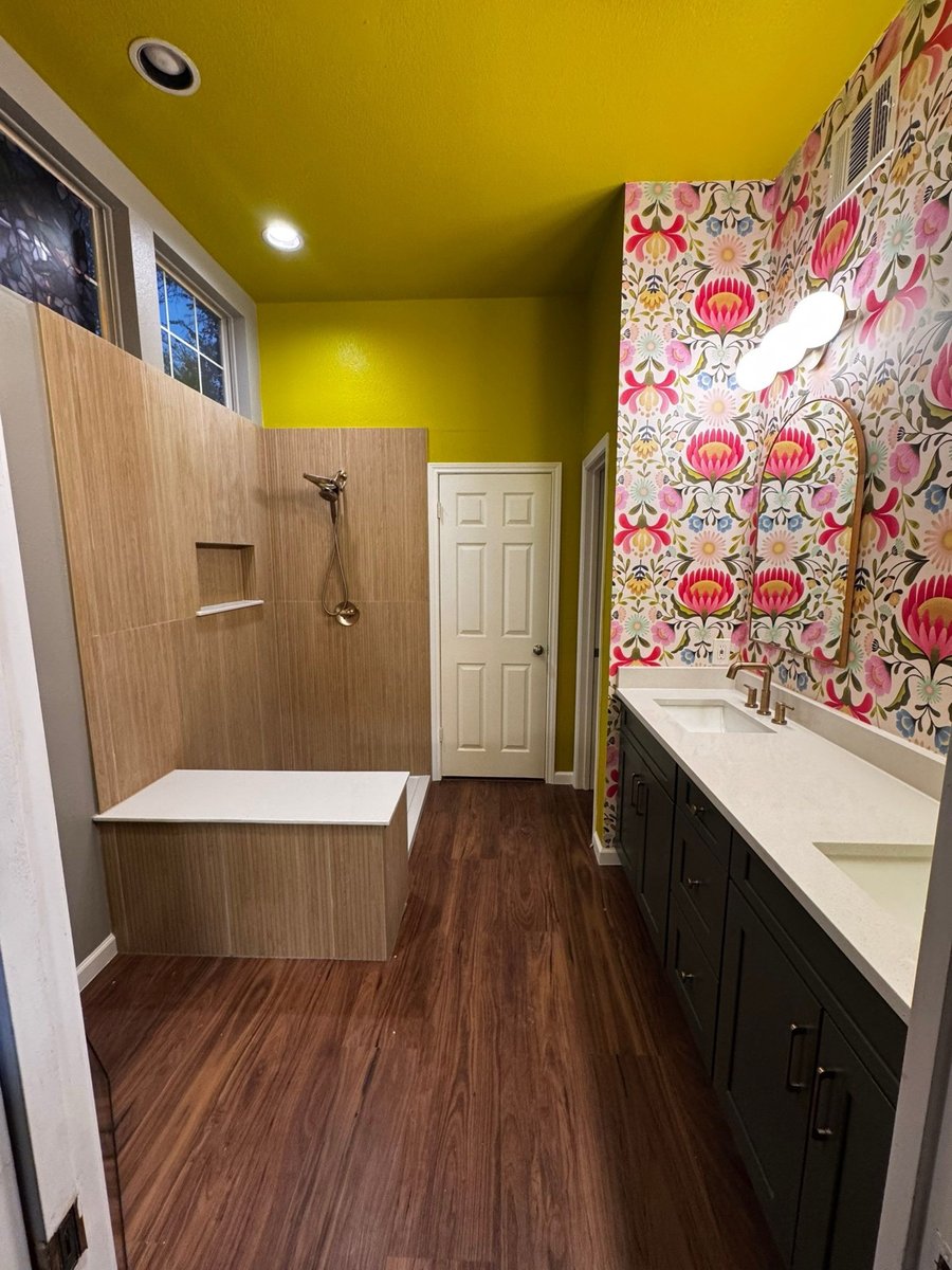Bright bathroom with chartreuse ceiling, wood-look shower, and floral accent wall
