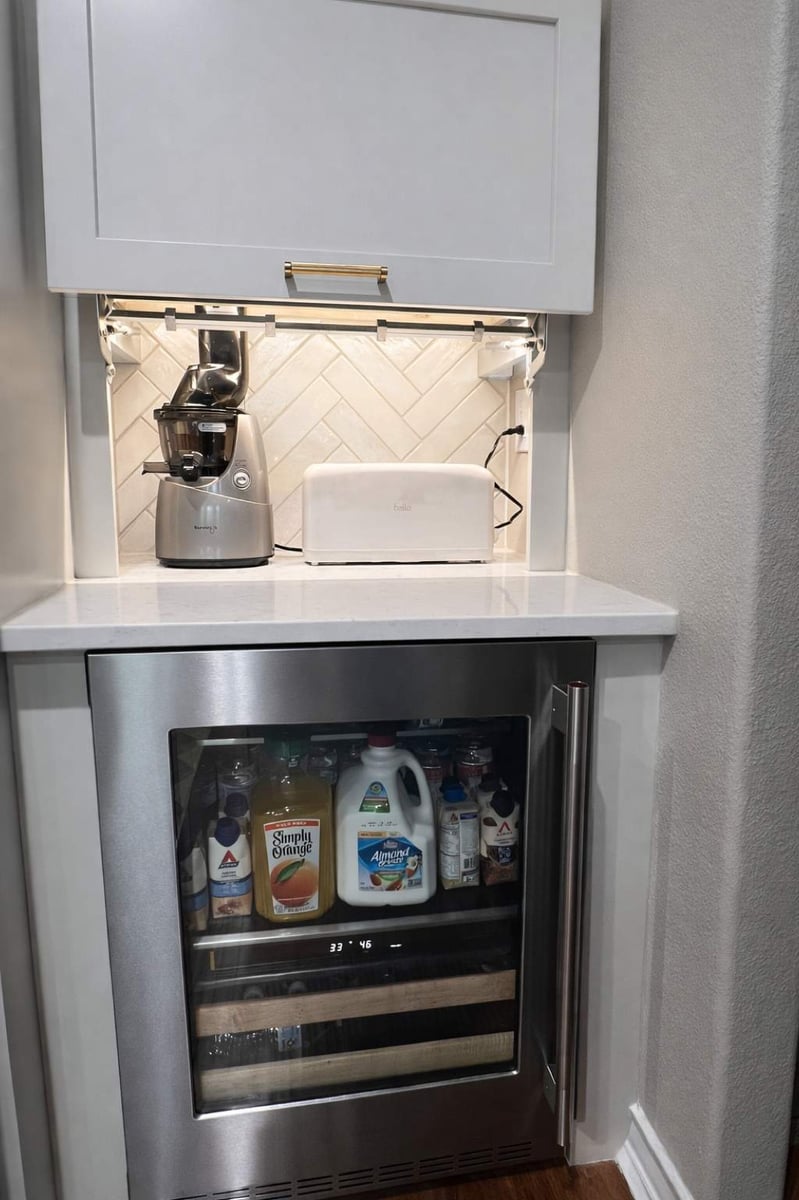 Built-in beverage fridge under a quartz counter with lift-up appliance garage cabinet
