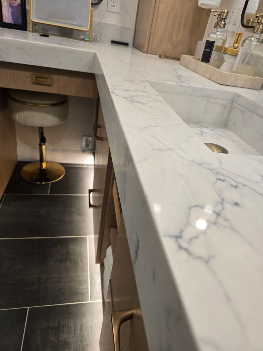Close-up of marble waterfall counter edge with undermount sink and makeup vanity nook