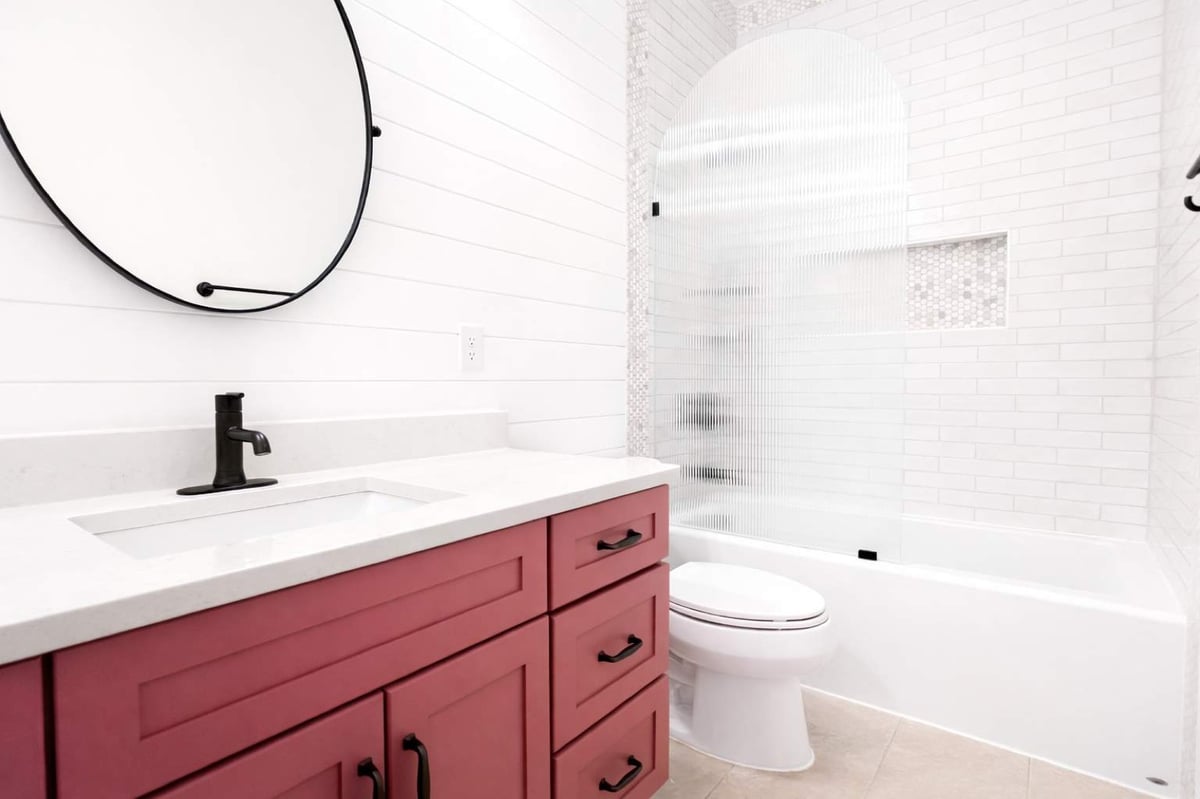 Rose vanity and arched fluted glass tub screen over white subway tile
