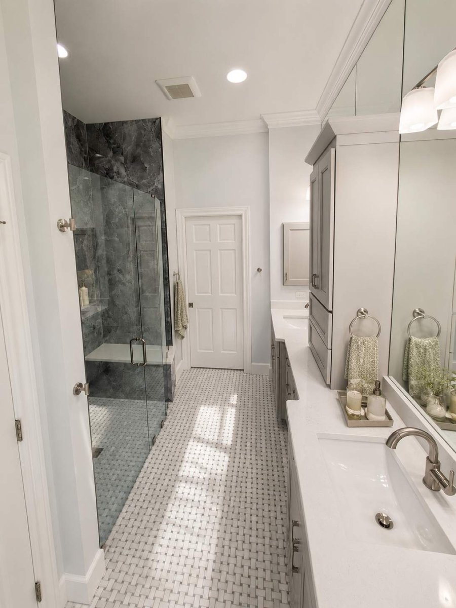 Bright bath with gray stone glass shower and styled gray double vanity