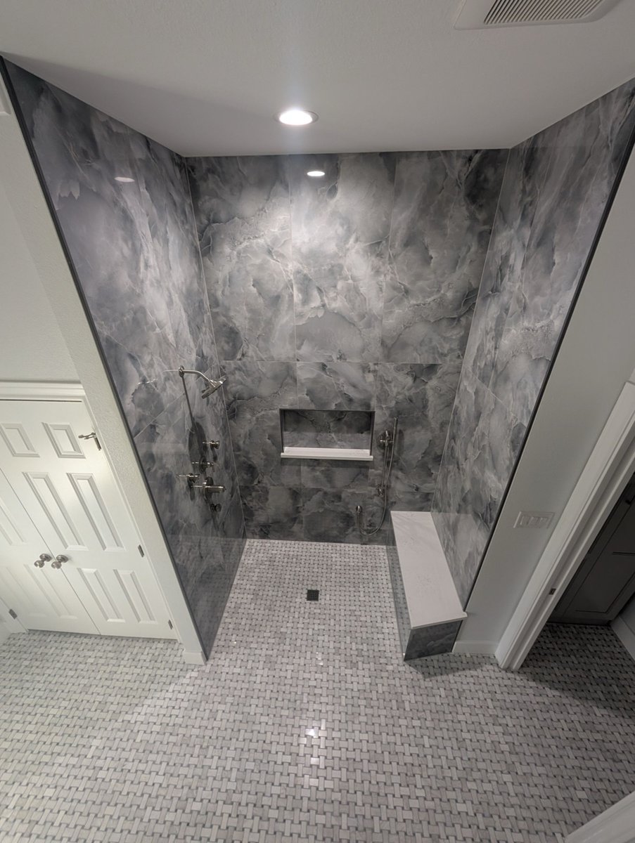 Doorless gray marble-look shower with niche and built-in bench seat