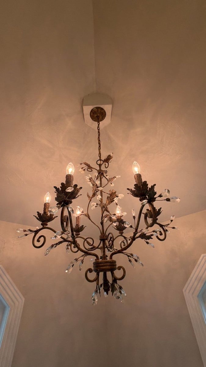 Wrought iron and crystal chandelier on a high angled ceiling