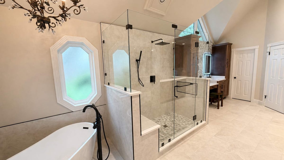 Wide view of master bath with glass shower, freestanding tub, and octagon windows