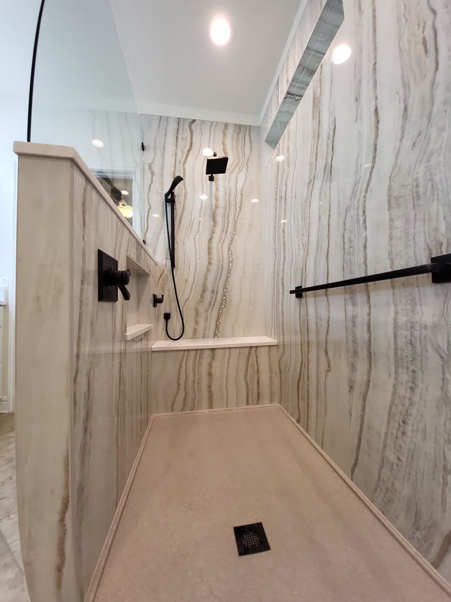 Accessible walk-in shower with floating bench, black handheld and grab bar