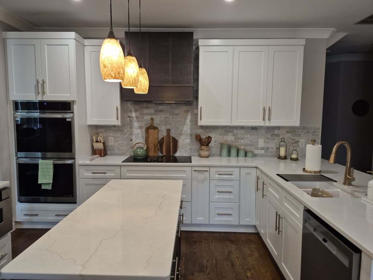 Stainless undermount sink in veined white quartz peninsula countertop