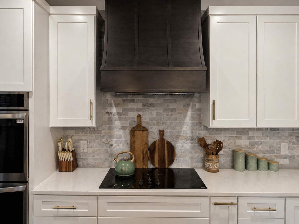 Black wood vent hood over cooktop with marble subway tile backsplash