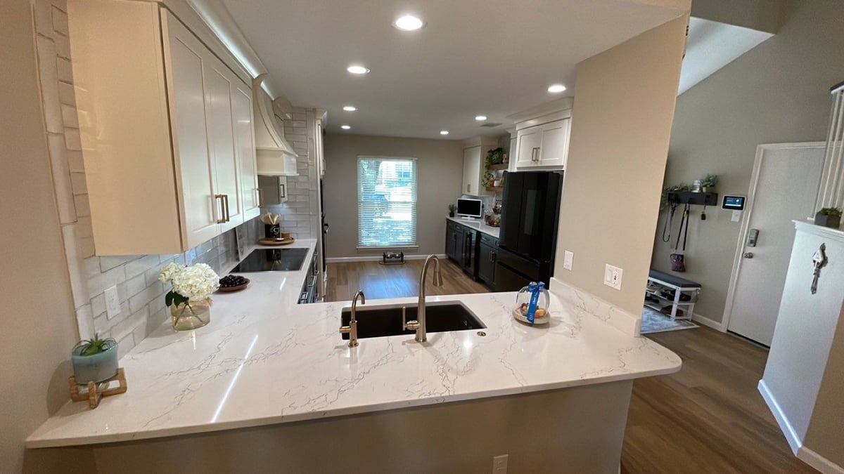 Wide kitchen view with coffee bar, dark cabinets and black French-door fridge