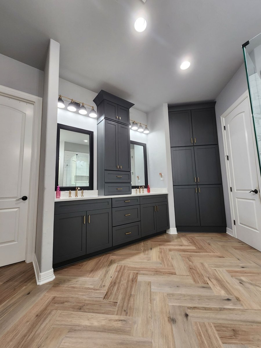 Charcoal double vanity with framed mirrors, brass faucets and tower cabinet
