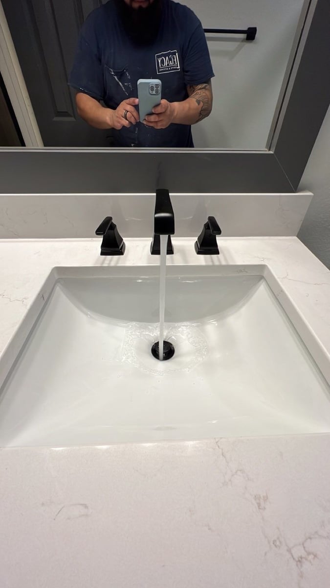 Square undermount sink with black widespread faucet and white quartz countertop
