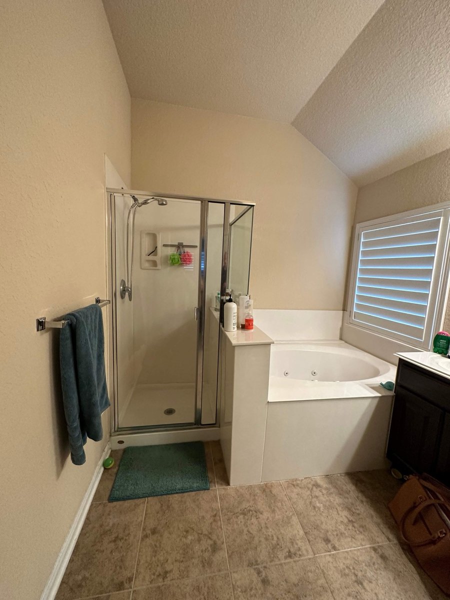 Original bathroom with framed glass shower stall, drop-in jetted tub, and beige tile